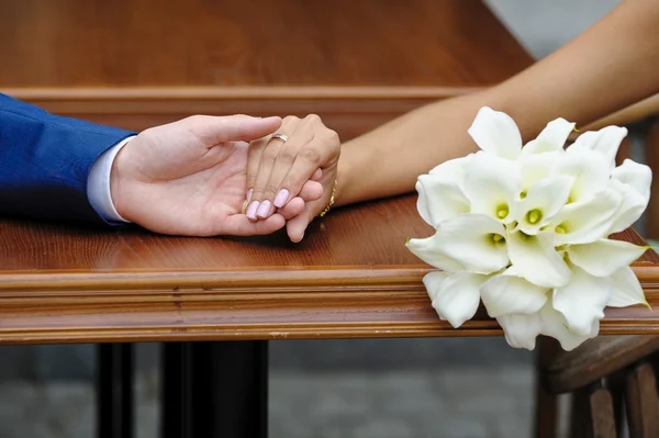 Наречена тримає руку нареченого і весільний букет — стокове фото