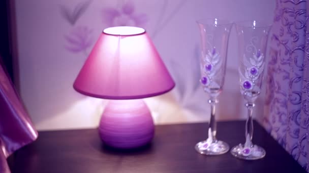 Λαμπτήρας και δύο ποτήρια στο τραπέζι στην κρεβατοκάμαρα — Αρχείο Βίντεο