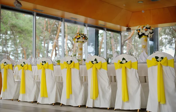 Decorated chairs on a celebratory banquet in yellow — Stock Photo, Image