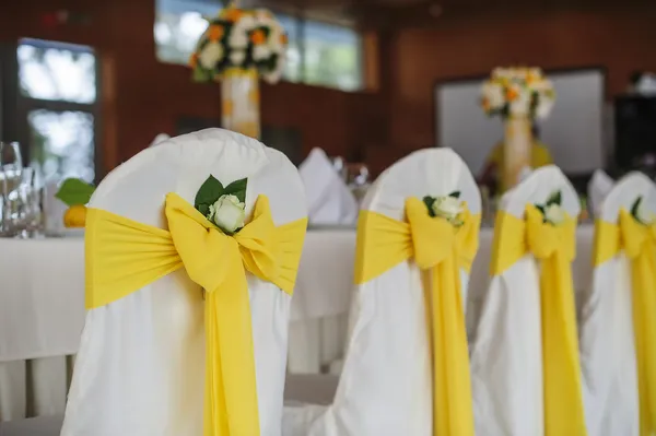 Cadeiras de casamento decoradas em um salão de banquetes — Fotografia de Stock