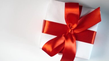 Beyaz hediye kutusu, beyaz arka planda kırmızı kurdele ve mesajın için yer var. Sevgililer Günü 'nde video talebi, anneler günü ya da doğum günü. En üstteki görüntü 4k