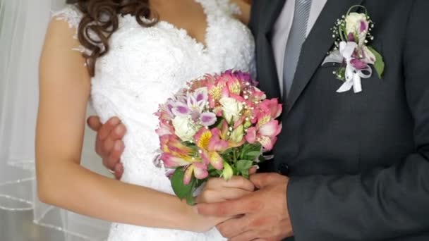 Nevěsta a ženich drží svatební kytice