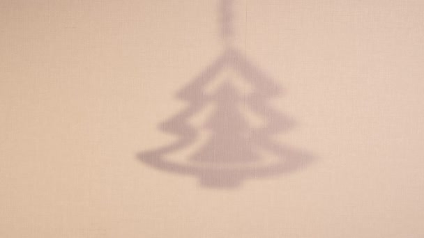 Abstract silhouette rotate shadow background of christmas tree falling on wall. Transparent blurry shadow of toy with place for text. 4k video footage for overlay on backdrop — Stock Video