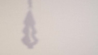 Abstract silhouette rotate shadow background of christmas tree falling on wall. Transparent blurry shadow of toy with place for text. 4k video footage for overlay on backdrop and mockup