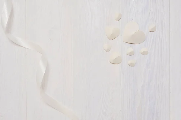 Mockup für Valentinstag Grußkarte. weiße Papierherzen und Schleife flach auf weißem Holzgrund mit Platz für Ihren Liebestext. Flache Lage, Foto-Attrappe von oben — Stockfoto