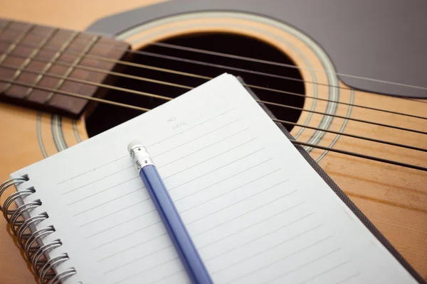 Notatnik i ołówek na gitarze — Zdjęcie stockowe