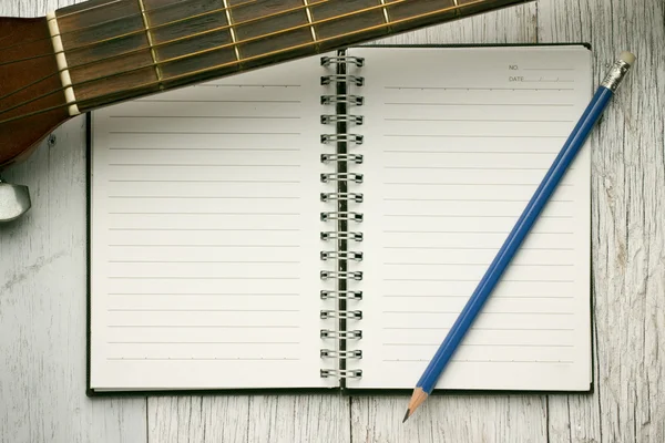 Notatnik i ołówek na gitarze — Zdjęcie stockowe