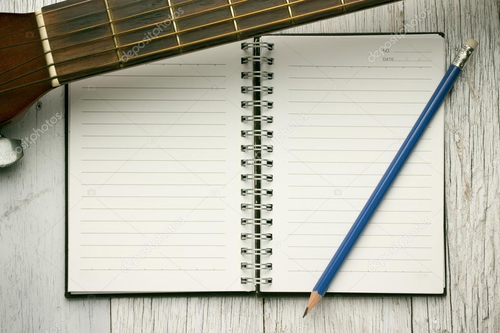 Notebook and pencil on guitar