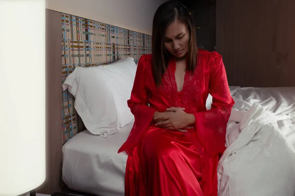 Жінка Атласному Нічному Одязі Червоному Одязі Болить Тримаючи Живіт Спальні — стокове фото
