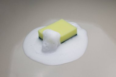 Yeşil sünger geri ve yerde köpük.