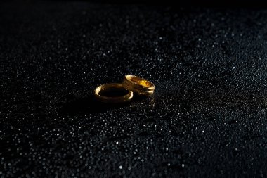 Karanlık bir arka planda yüzükler. Evlilik yüzükleri. Mücevherler.