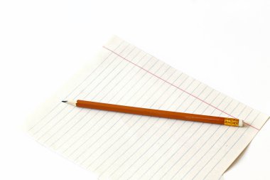 Beyaz arka planda bir kağıt parçasına kalem. Kalem ve defter. Yakın plan. Boşluğu kopyala