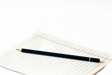 Beyaz arka planda bir kağıt parçasına kalem. Kalem ve defter. Yakın plan. Boşluğu kopyala