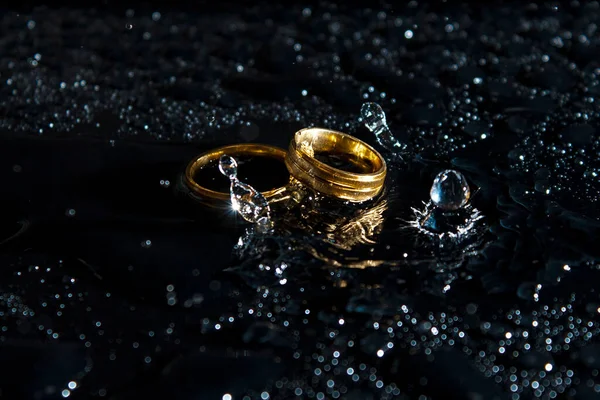 Ringe Auf Dunklem Hintergrund Eheringe Schmuck Wasserspritzer — Stockfoto