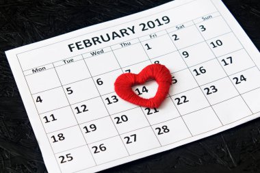 14 Şubat 'ta kırmızı kalplerle takvim sayfası, siyah arkaplanda sevgililer günü. Sevgililer Günü tebrik kartı.