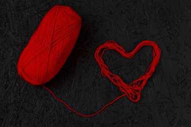 14 Şubat 'ta kırmızı kalpler, siyah arka planda sevgililer günü. Sevgililer Günü tebrik kartı. İpin kalbi. İpliğin kalbi. İplik, tekstil, iplik. 8 Mart