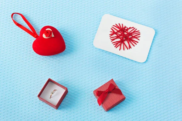Kırmızı kalpler ve halka mavi arka planda. Sevgililer Günü. Sevgililer Günü tebrik kartı. Bir evlilik teklifi. Nişan.
