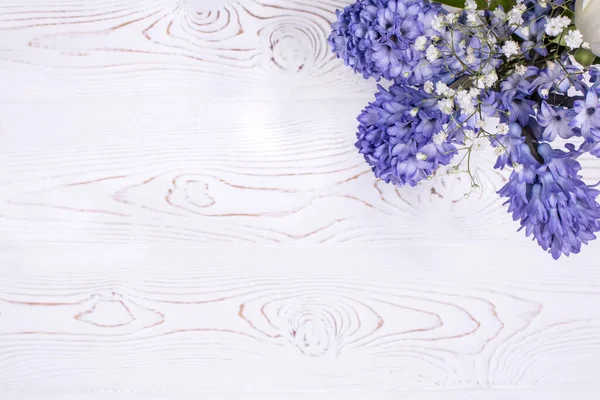 Composizione primaverile con fiori di giacinto blu su un piano in legno bianco imbiancato a calce. Piatto. Copia spazio per testo Fotografia Stock