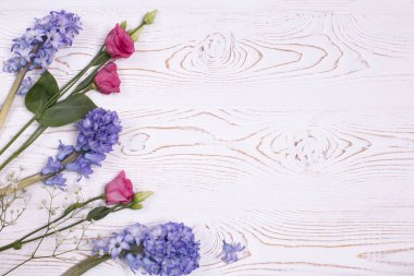 Bahar ya da yaz kompozisyonu mavi sümbül çiçekleri, pembe çiçekler ve beyaz çigila ile beyazlatılmış bir masa. Metin için alanı kopyala