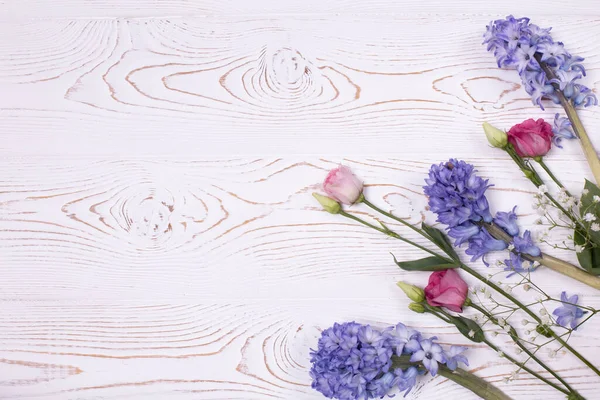 Composizione primaverile o estiva con vista dall'alto di fiori di giacinto blu, fiori rosa e gypsophila bianca su un tavolo imbiancato a calce. Copia spazio per testo — Foto Stock