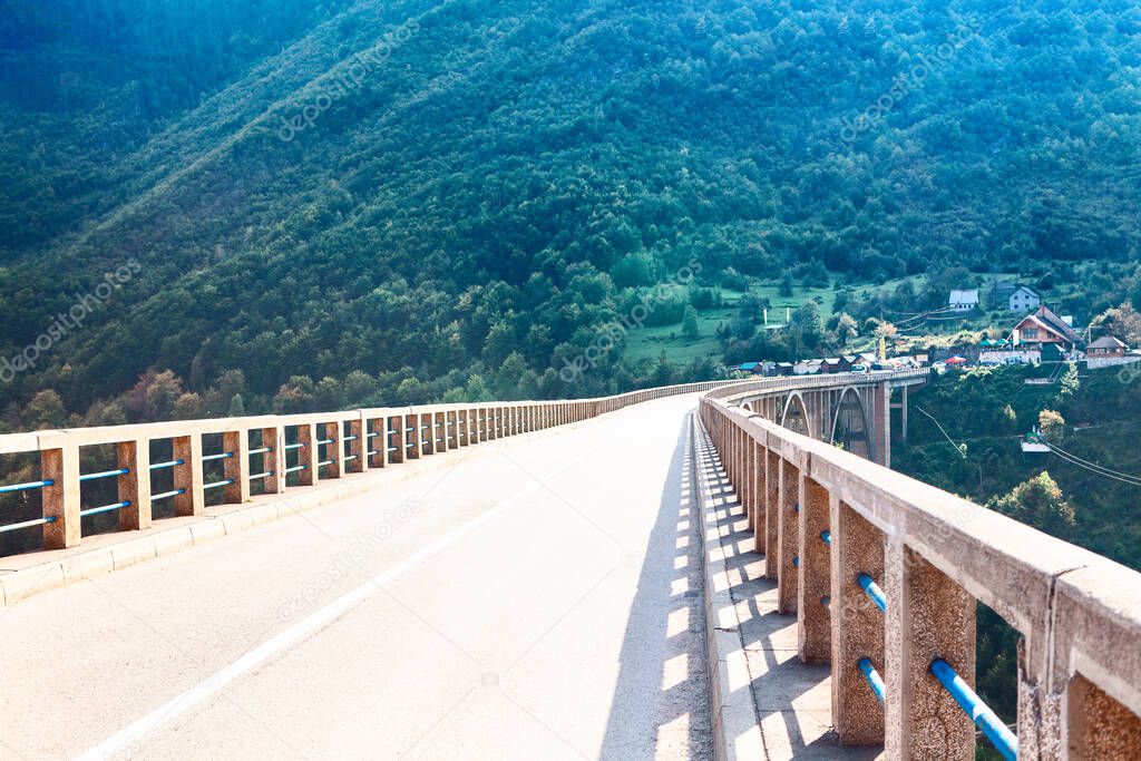 Driving on the mountain bridge . Djurdjevica Tara Bridge in Montenegro . Highway with balustrade