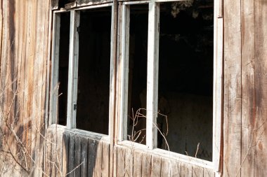 Kırık camlı klasik ahşap pencere çerçevesi. Terk edilmiş evin ahşap duvarı. 