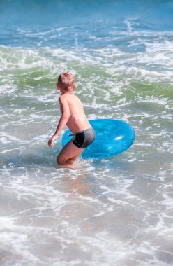 Deniz dalgalarındaki çocukla ilgili tehlikeli bir durum. Mevsimlik genç bir çocuk