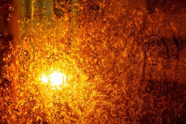 Bardakta buz var. Donmuş yüzeyde parlayan