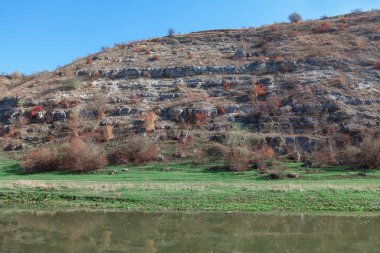 Rocky Hill 'li Idyllic nehir kıyısı. Nehir kenarı manzarasında ata bin 