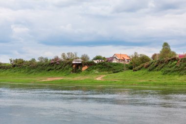 Nehirli kırsal bir yer. Bulutlu bir günde kırsal nehir kenarı 
