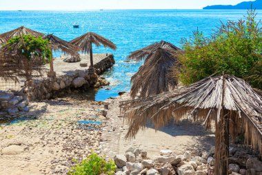 Vahşi tropik plaj. Sahilde egzotik güneş şemsiyeleri 