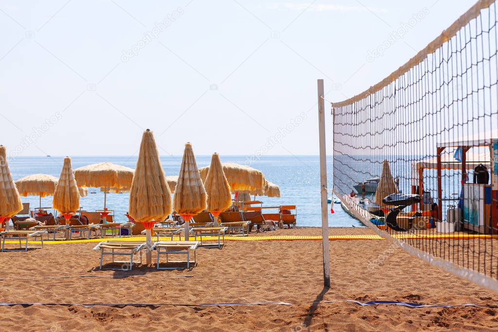 Beach volleyball court . South sandy beach with sun lounges . Summer vacation concept 