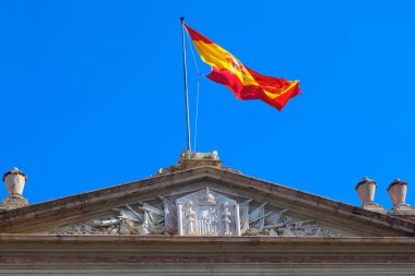 Üstünde İspanyol bayrağı var. İspanya Ulusal Bayrağı Dalgalanıyor, binanın en üst kısmı. 