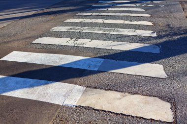 Yaya geçidi işaretleri. Şehir asfalt sokağı. Yoldaki gölgeler 