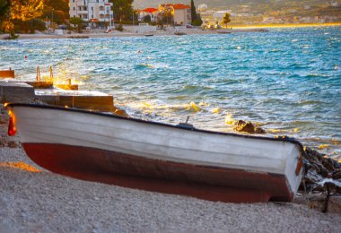 Alacakaranlıkta deniz kıyısında bir tekne