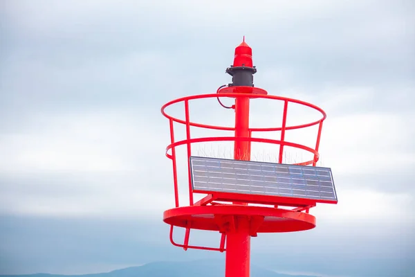 Sea lighthouse with solar battery . Red coast lighthouse