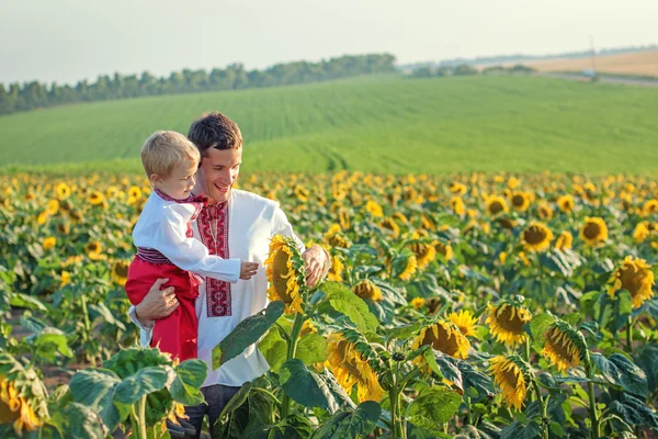 A father and young son in Ukrainian sunflower shirts considering — Stock Photo, Image