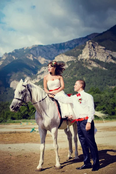 Bride and groom on the background of mountains — Stock Photo, Image