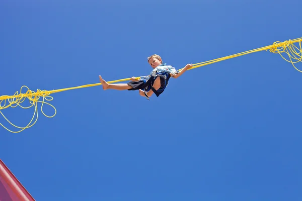 Garçon sautant dans les airs devant un ciel bleu — Photo