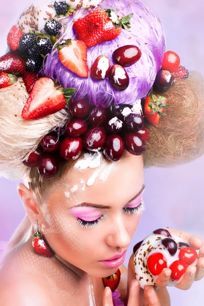 Una mujer con una fruta sobre el fondo rosa — Foto de Stock