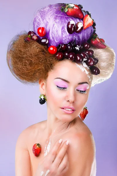 A woman with a fruit on the pink background — Stock Photo, Image