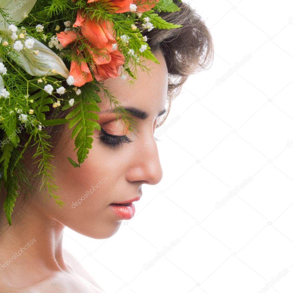 A beautiful girl with flowers on her head on a white background
