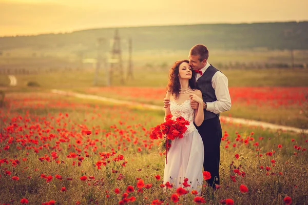 Bruden och brudgummen i en vallmo — Stockfoto