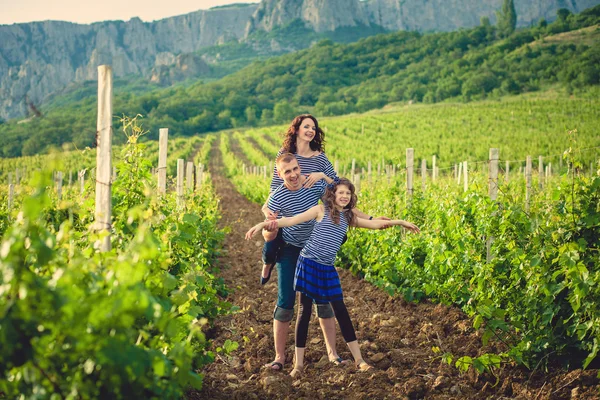 Family in the striped shirt in the vineyard — Stock Photo, Image