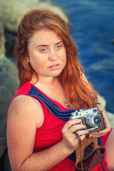 Redhead girl with camera — Stock Photo, Image