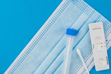 Coronavirus covid 19 için antijen testi yapın. Laboratuvar kartı koronası hızlı test cihazı. Olumsuz sonuç. Burun çubuğu, tüp ve maske takın. 