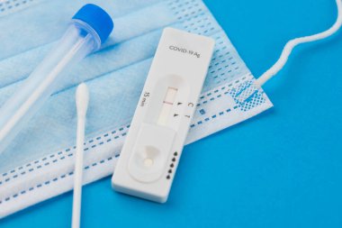 Coronavirus covid 19 için antijen testi yapın. Laboratuvar kartı koronası hızlı test cihazı. Olumsuz sonuç. Burun çubuğu, tüp ve maske takın. 