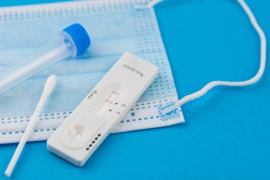 Coronavirus covid 19 için antijen testi yapın. Laboratuvar kartı koronası hızlı test cihazı. Olumsuz sonuç. Burun çubuğu, tüp ve maske takın. 