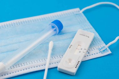Coronavirus covid 19 için antijen testi yapın. Laboratuvar kartı koronası hızlı test cihazı. Olumsuz sonuç. Burun çubuğu, tüp ve maske takın. 