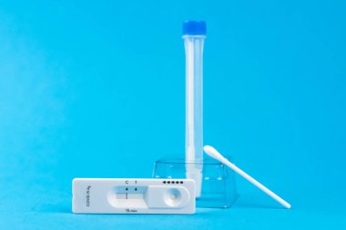 Coronavirus covid 19 için antijen testi yapın. Laboratuvar kartı koronası hızlı test cihazı. Olumsuz sonuç. Burun çubuğu, tüp ve maske takın. 